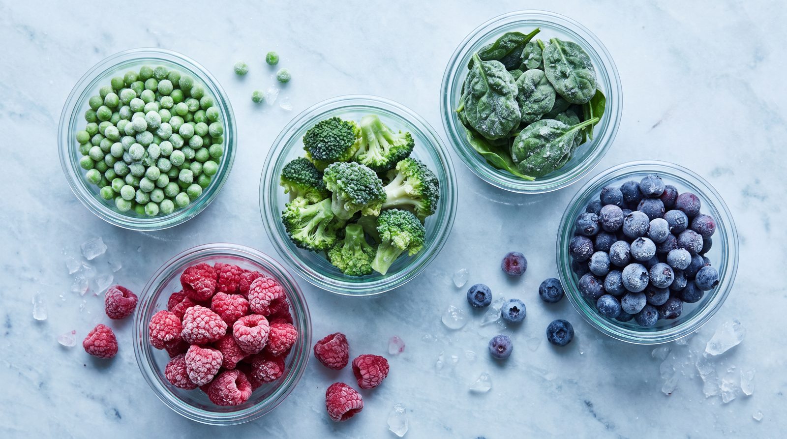Tiefgekühltes Gemüse und Beeren in Glasschalen